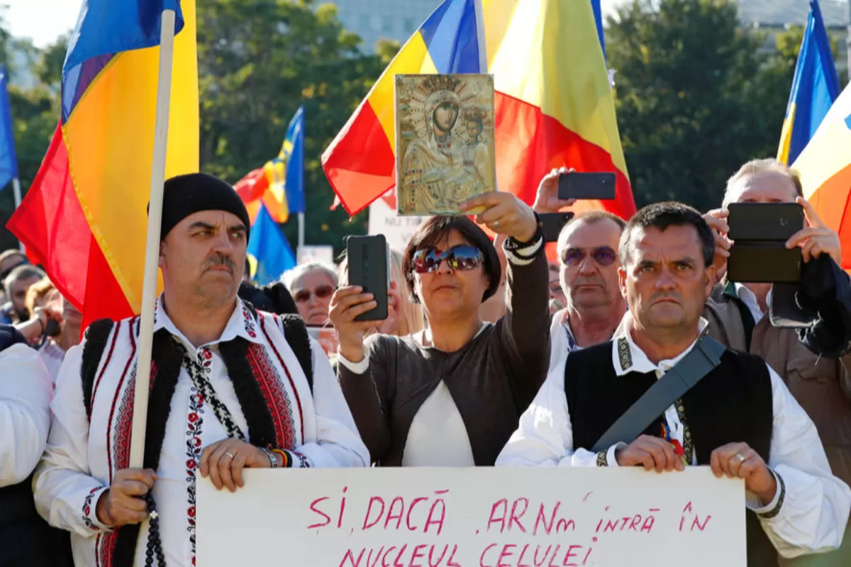 Români care poartă steaguri naționale participă la un protest față de noile măsuri dispuse de guvernul României în timpul celui de-al patrulea val al pandemiei de coronavirus în fața sediului guvernului din București, România, 02 octombrie 2021.