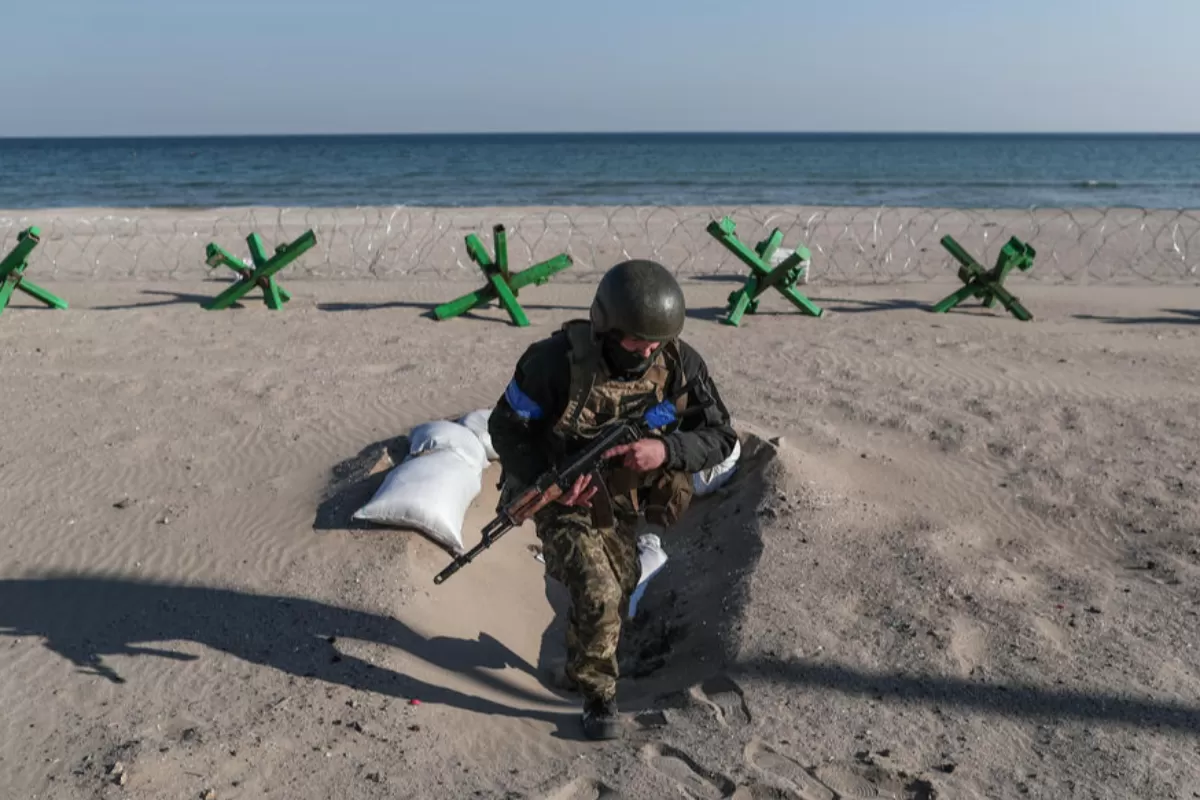 A Ukrainian soldier stands guard with his gun next to barricades at the beachfront near Lusanivka in south Ukrainian city of Odesa, in Ukraine, 21 March 2022.