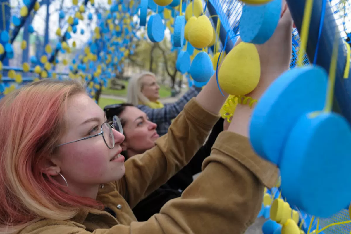 Ukrainians hang symbolic blue and yellow eggs at a installation called 'A life corridor' in the downtown of Western Ukrainian city of Lviv, Ukraine, 15 April 2022, to pay respect to Ukrainians who died during the Russian invasion. 