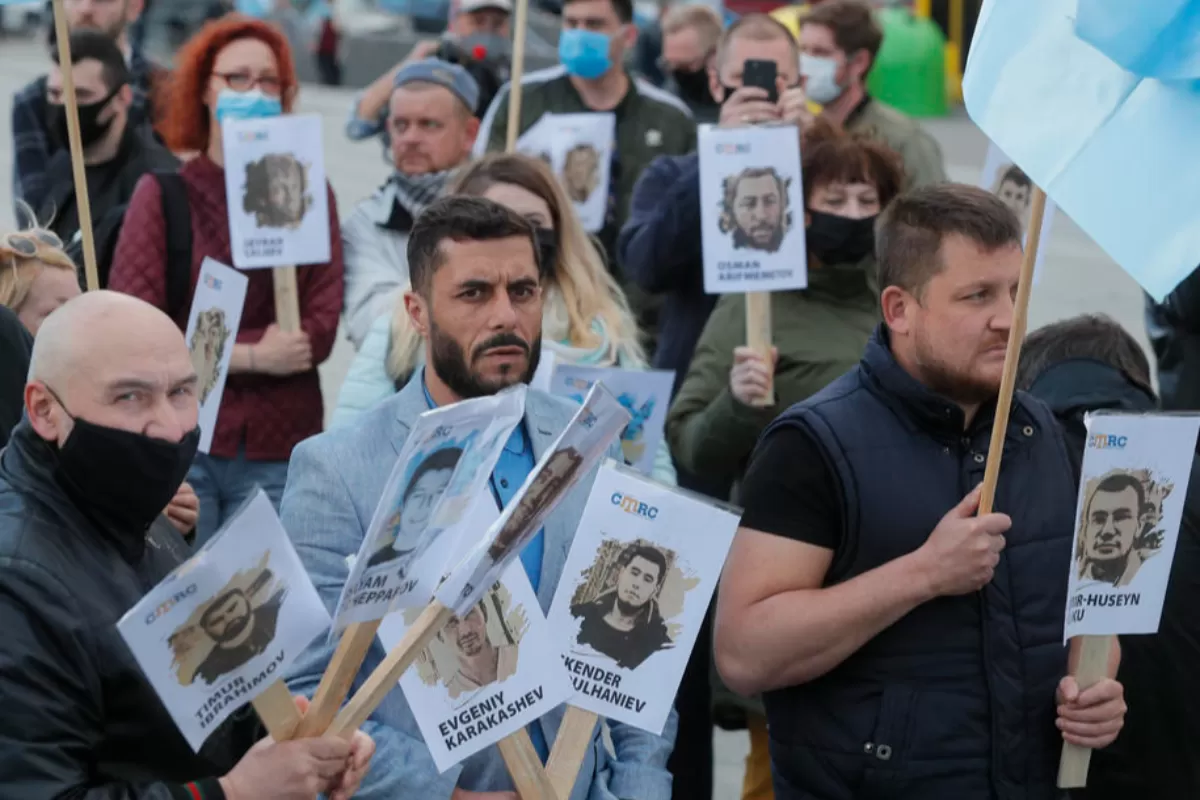 Tătari din Crimeea cu portrete ale activiștilor tătari arestați de Rusia în Crimeea după anexarea acesteia în 2014, în timpul unei manifestații de comemorare în Piața Independenței din Kiev, Ucraina, 18 mai 2020.
