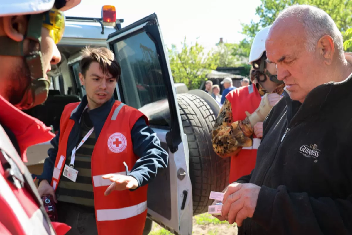 Membri ai filialei Crucii Roșii din Harkov distribuie medicamente și oferă ajutor medical cetățenilor locali în micul oraș Staryi Saltov, recucerit de armata ucraineană la 04 mai 2022, în zona Harkov, Ucraina, 20 mai 2022.