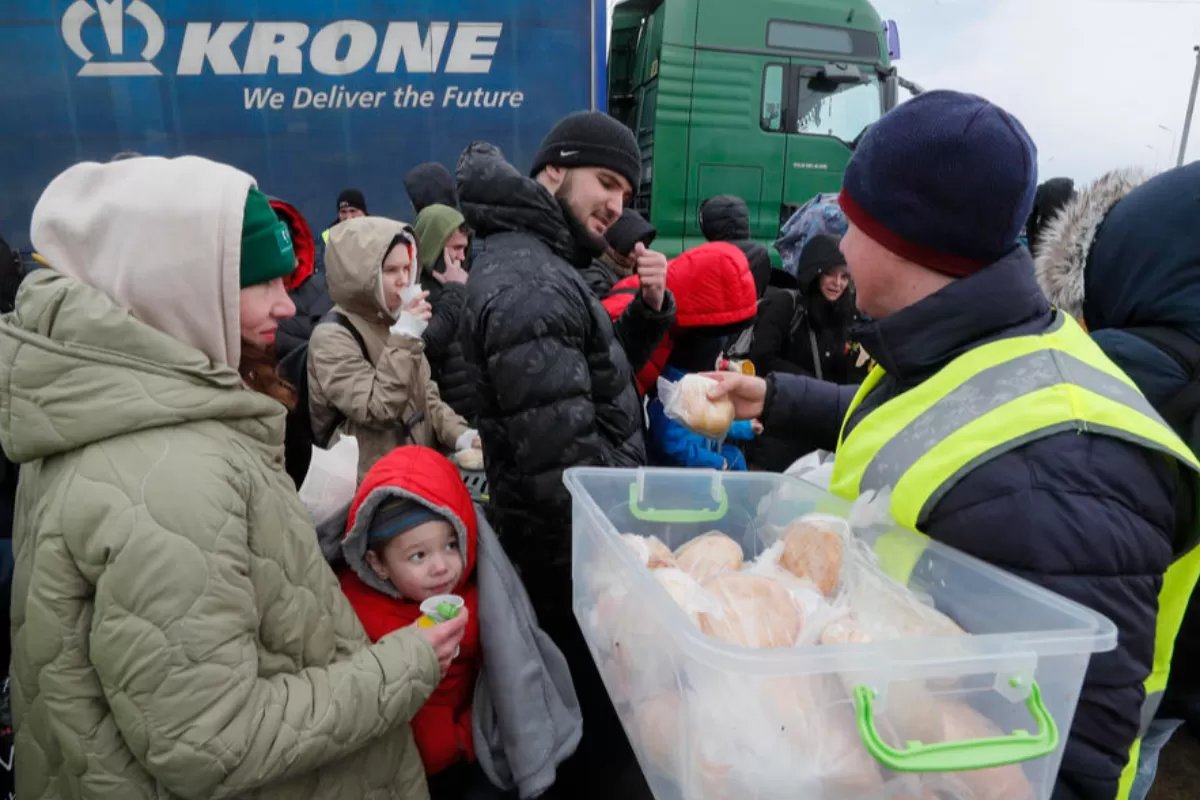 Voluntarii distribuie mâncare și ceai cald pentru persoanele care așteaptă la punctul de trecere a frontierei Ucraina - România, nu departe de orașul Cernăuți, Ucraina, 10 martie 2022.