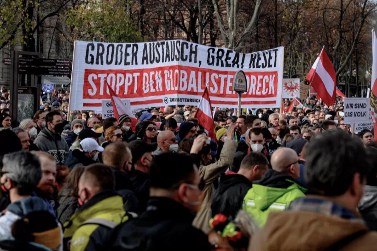 Protestatari afișează un banner pe care scrie „Grosser Austausch, great Reset Stoppt den Globalistendreck” („Mare schimb, mare resetare, opriți murdăria globalistă”) în timpul unei demonstrații împotriva măsurilor guvernului austriac de a încetini pandemia COVID-19, boală cauzată de coronavirusul SARS-CoV-2 în Viena, Austria, 20 noiembrie 2021.