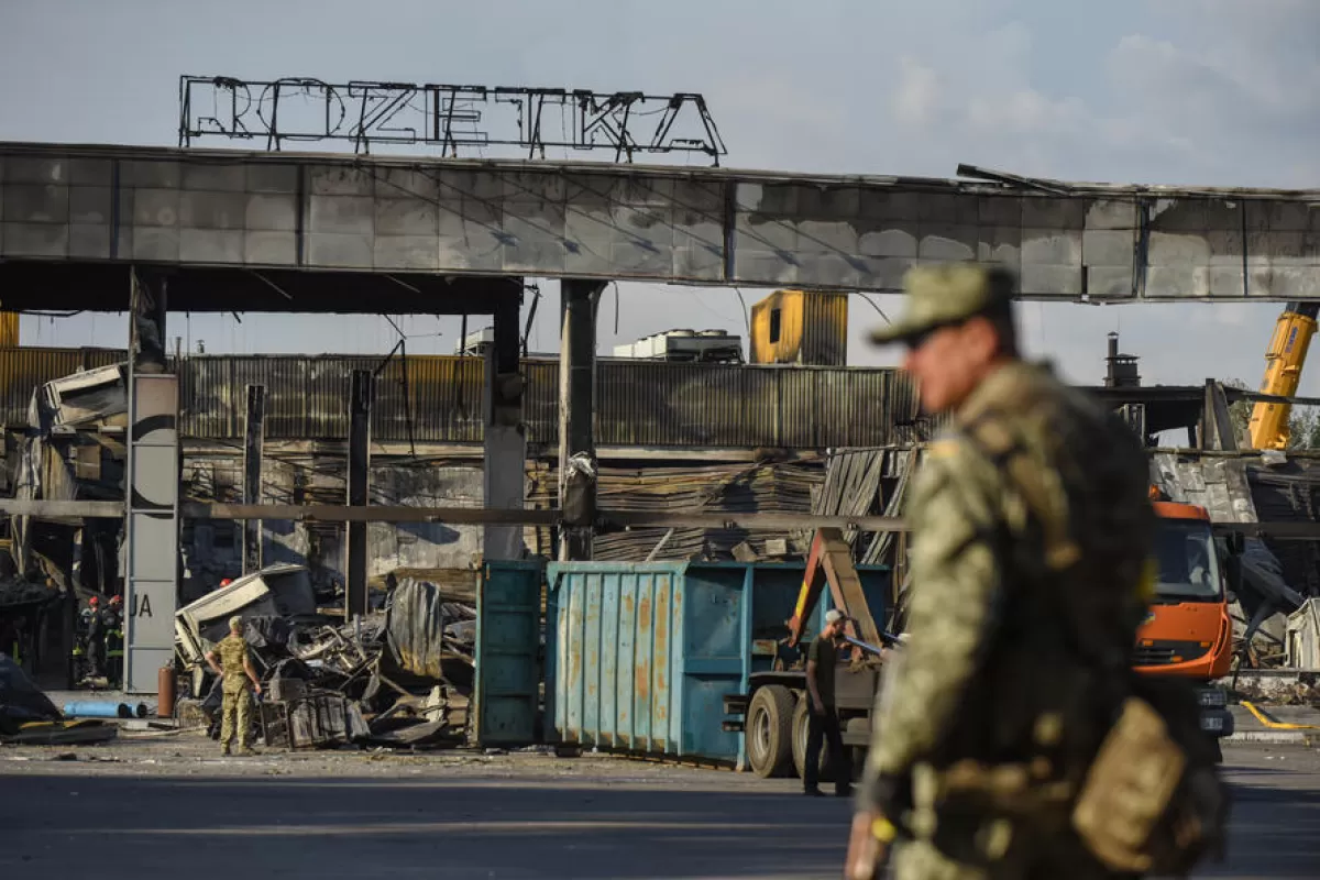 Militari ucraineni stau de pază lângă rămășițele mall-ului Amstor distrus din Kremenciuk, Ucraina, 28 iunie 2022.