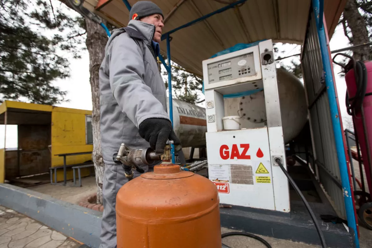 Un muncitor umple o butelie de gaz la o benzinărie de lângă satul Antonești din raionul Ștefan Vodă din Moldova, 13 martie 2022.