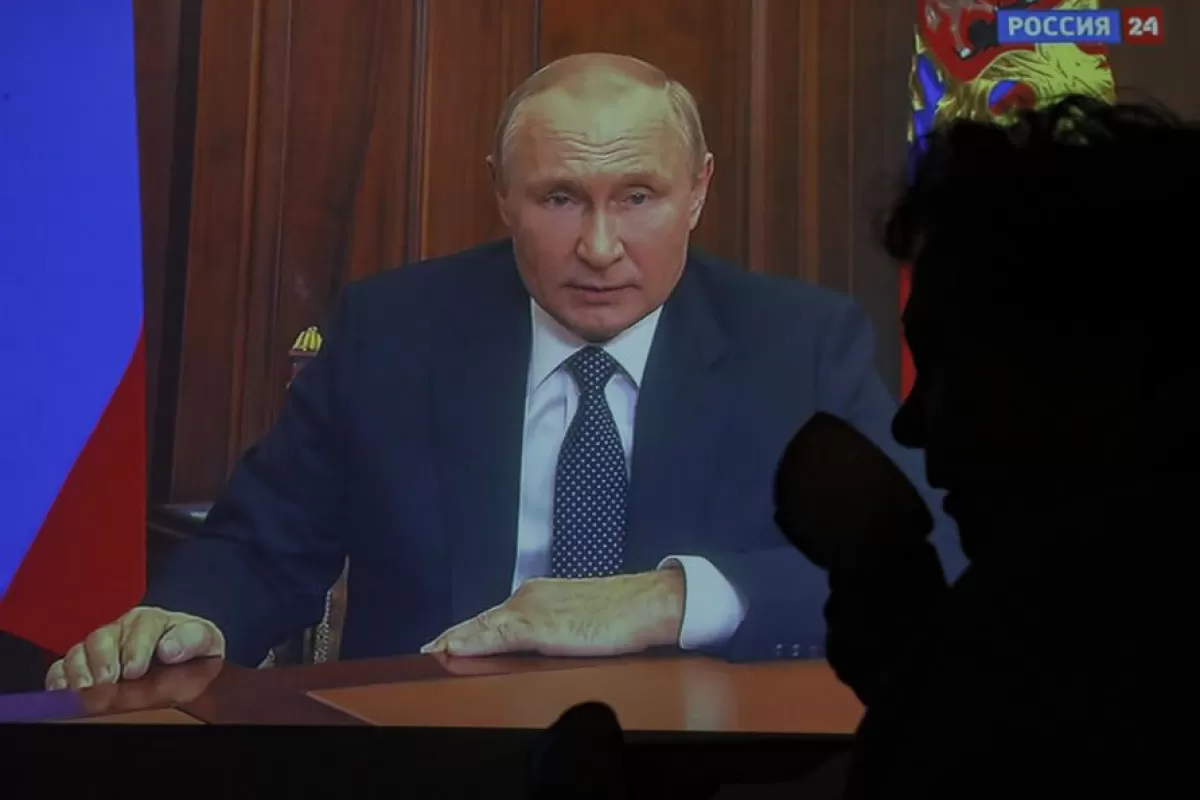 O femeie este e reflectată pe un ecran de televizor unde președintele rus Vladimir Putin ţine un discurs adresat națiunii, la Moscova, Rusia, 21 septembrie 2022.