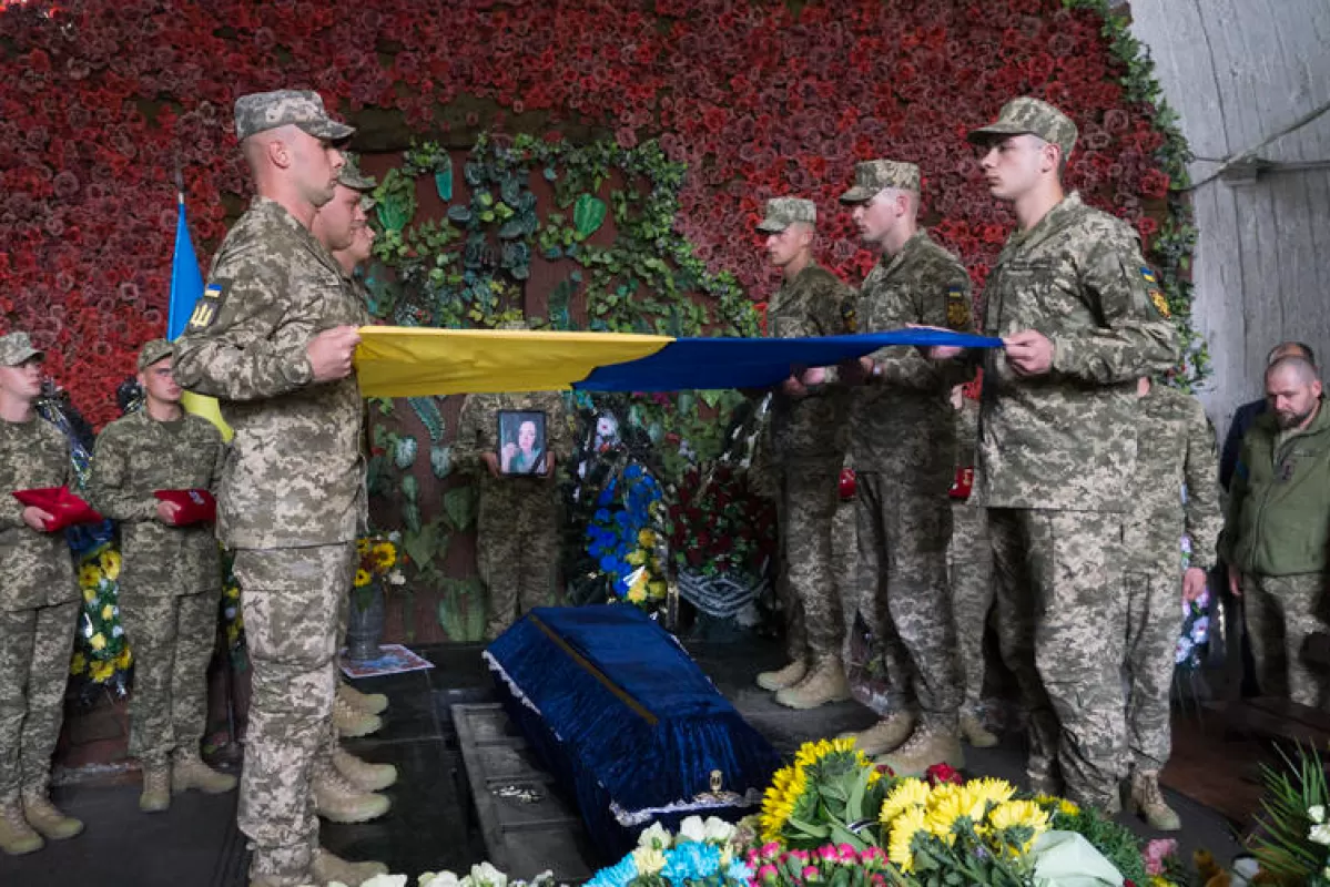 Camarazii țin un steag național deasupra sicriului militarului ucrainean Olga Simonova, ucisă de trupele ruse în regiunea Donețk, în timpul înmormântării de la Kiev, Ucraina, 16 septembrie 2022.