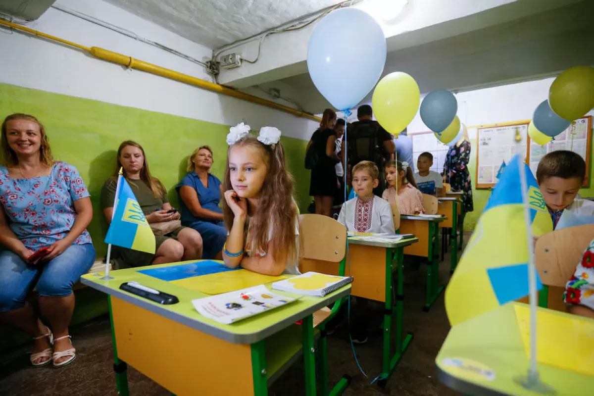 Дети внутренне перемещенных лиц принимают участие в уроке патриотизма в бомбоубежище в Одессе, 1 сентября 2022 года.