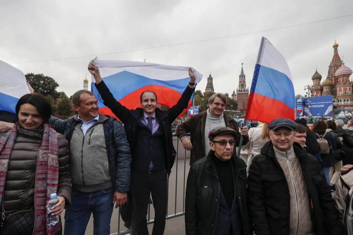 Rușii sărbătoresc după o ceremonie de semnare a tratatelor privind aderarea noilor teritorii la Rusia în centrul orașului Moscova, Rusia, 30 septembrie 2022.