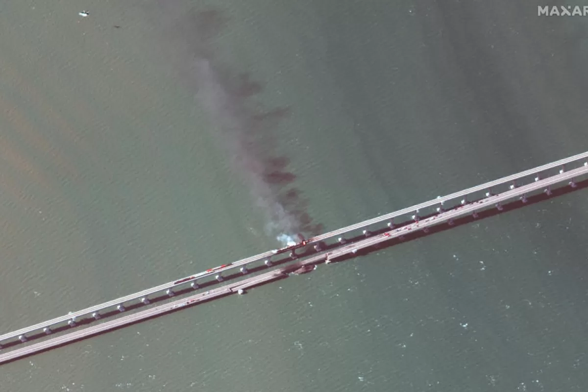 O imagine din satelit pusă la dispoziție de Maxar Technologies arată fum și o parte prăbușită a podului peste strâmtoarea Kerci din Crimeea, 8 octombrie 2022.