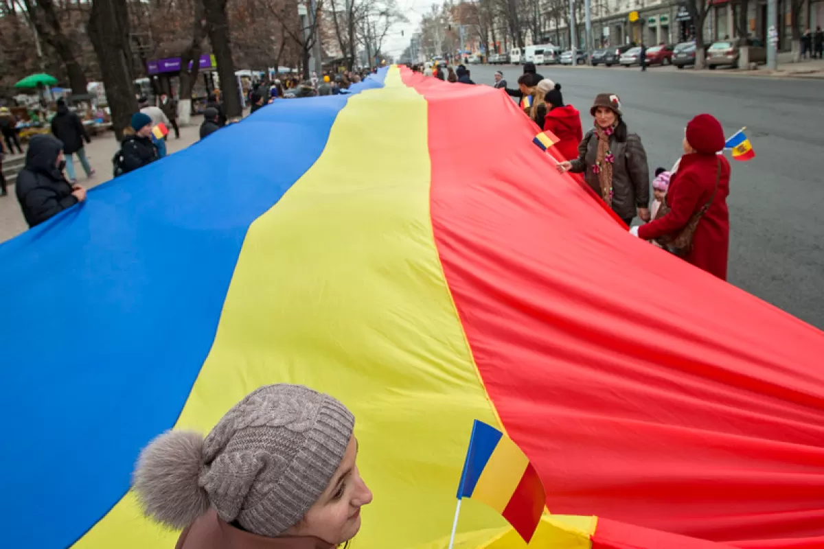 Oamenii defilează cu un drapel tricolor gigant cu lungimea de aproximativ un kilometru în Piața Marii Adunări Naționale din Chișinău, Republica Moldova, 01 decembrie 2016.