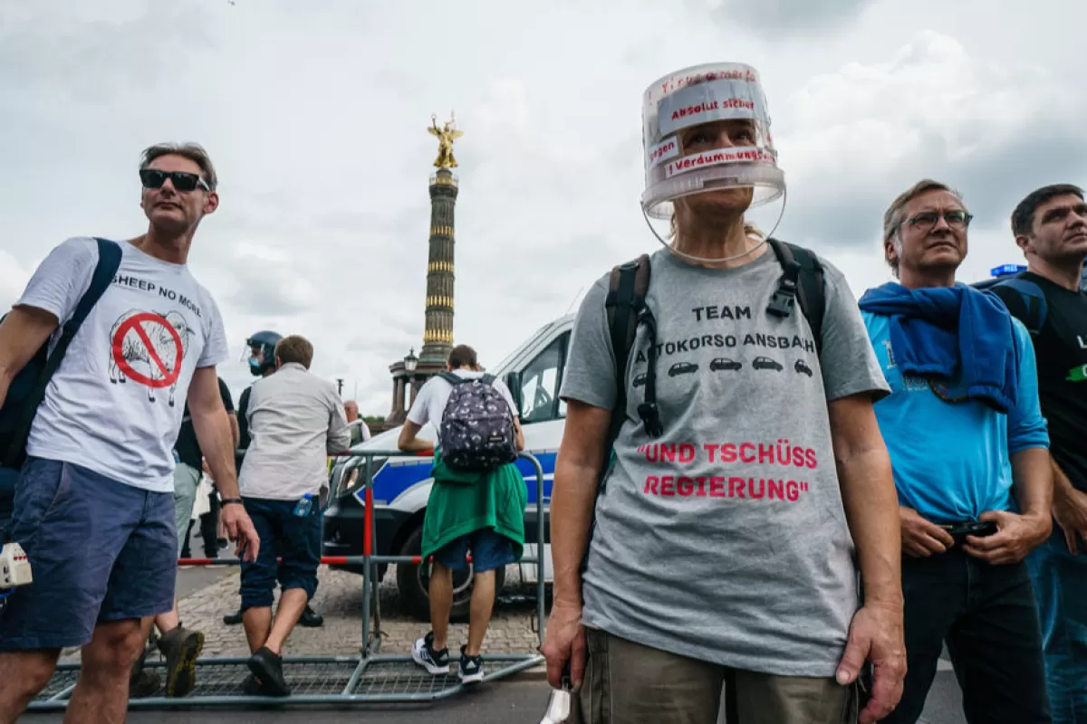 Un protestatar poartă o găleată pe cap pe care scrie „Absolut în siguranță împotriva virusului de atenuare a minții” în timpul unui protest neautorizat lângă Coloana Victoriei din Berlin, Germania, 1 august 2021.