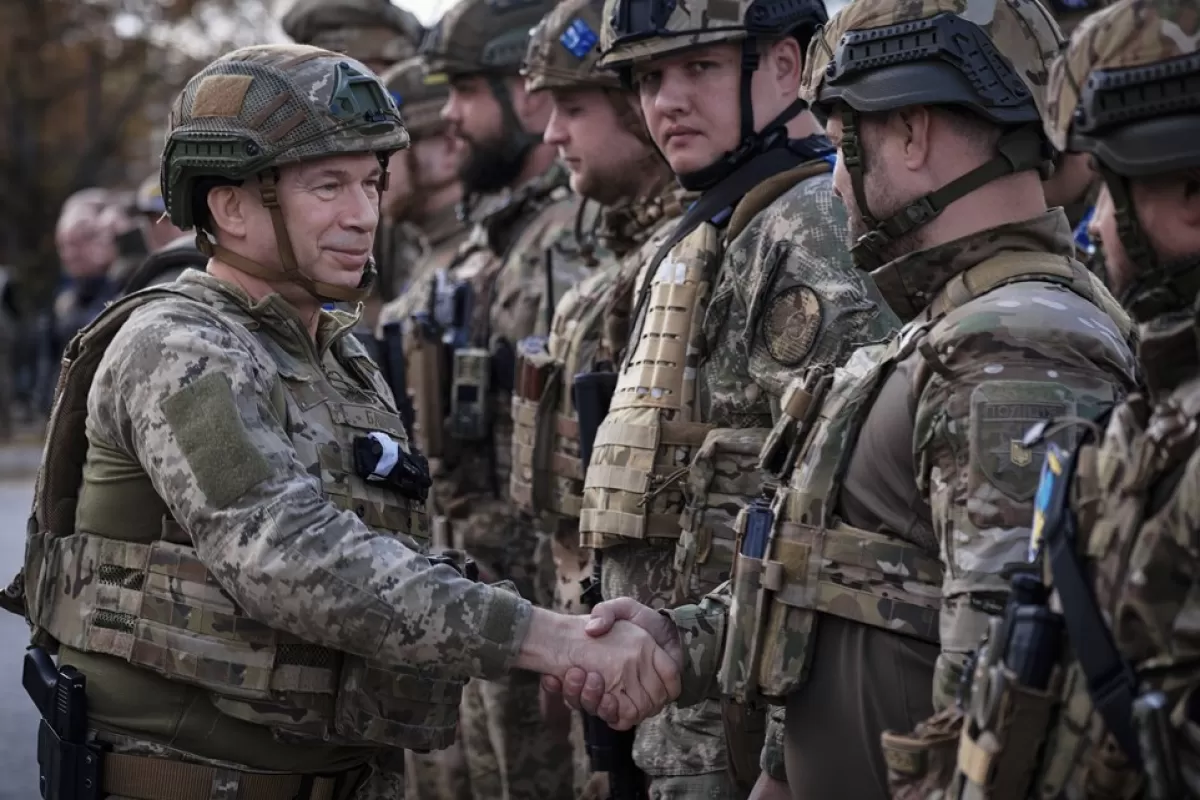 Oleksandr Syrskyi, the commander of the Ukrainian Ground Forces, shakes hands with Ukrainian servicemen during the ceremony of raising the National flag in the recently recaptured city of Lyman, Donetsk area, Ukraine, 04 October 2022.