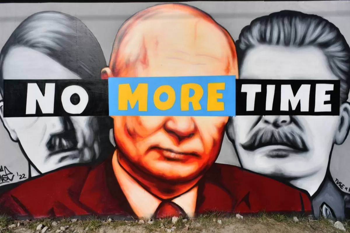O pictură murală care îi arată pe Hitler, Putin și Stalin, creată de artistul graffiti Tuse, este pulverizată pe un perete din Gdansk, nordul Poloniei, 22 martie 2022.