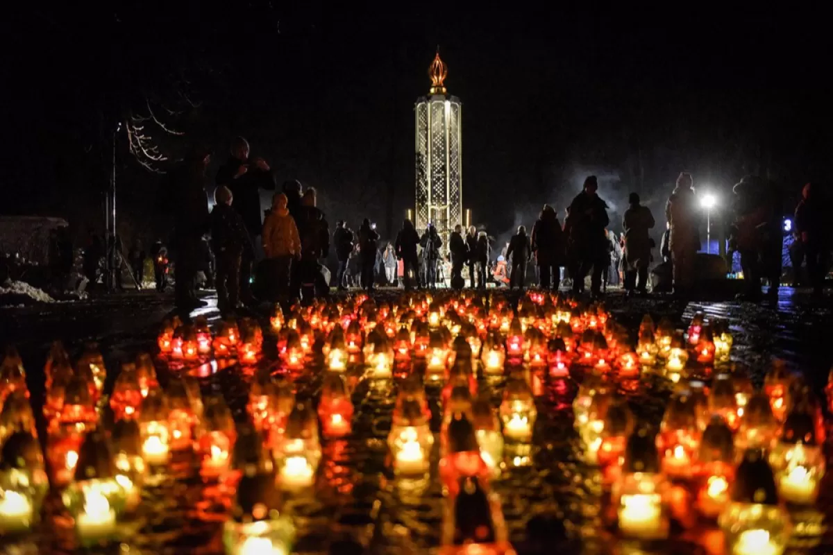 Oamenii aprind lumânări la Muzeul Național al complexului genocidului Holodomor din Kiev, Ucraina, 26 noiembrie 2022.