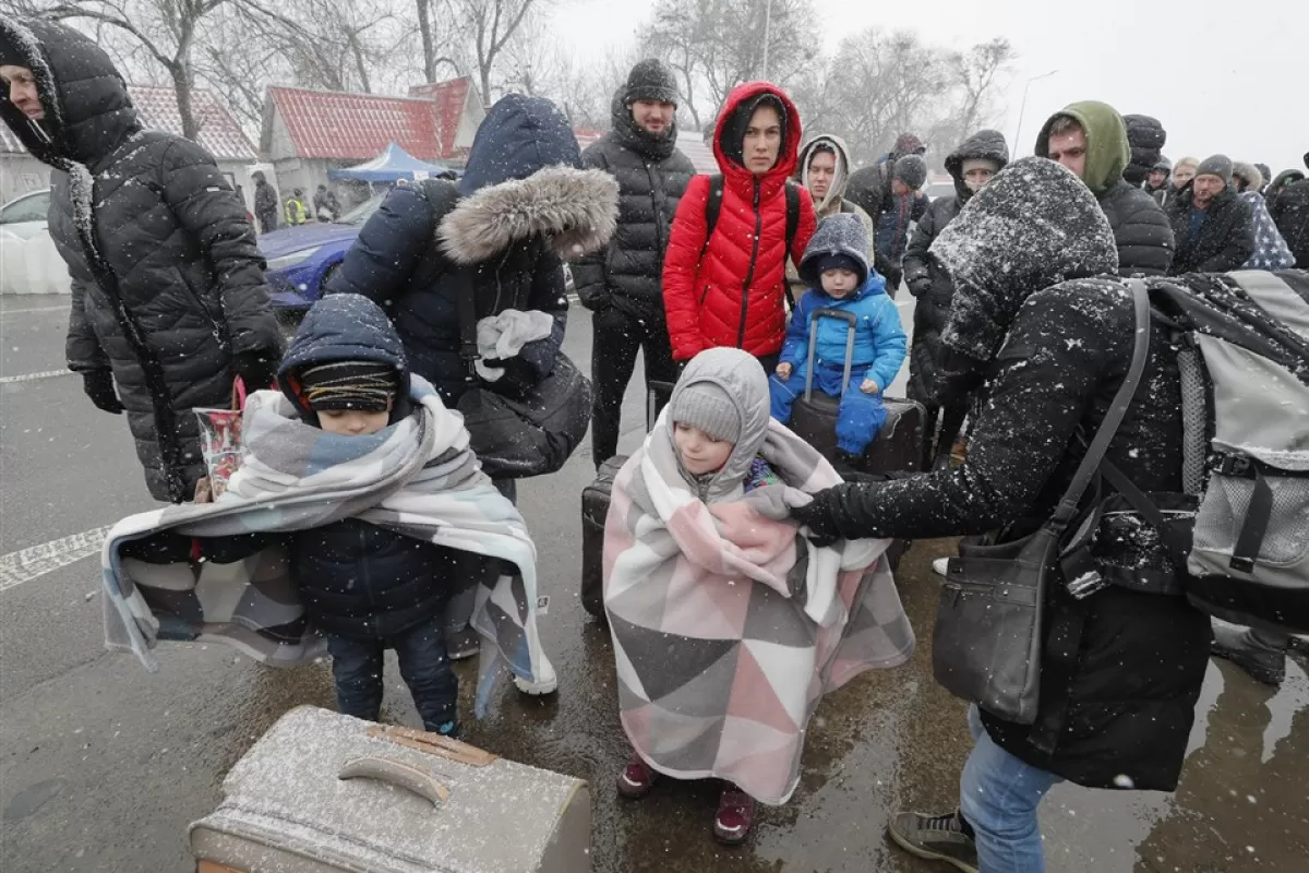 Persoane cu copii stau la coadă la punctul de trecere a frontierei Ucraina - România, nu departe de orașul Cernăuți, Ucraina, 10 martie 2022.