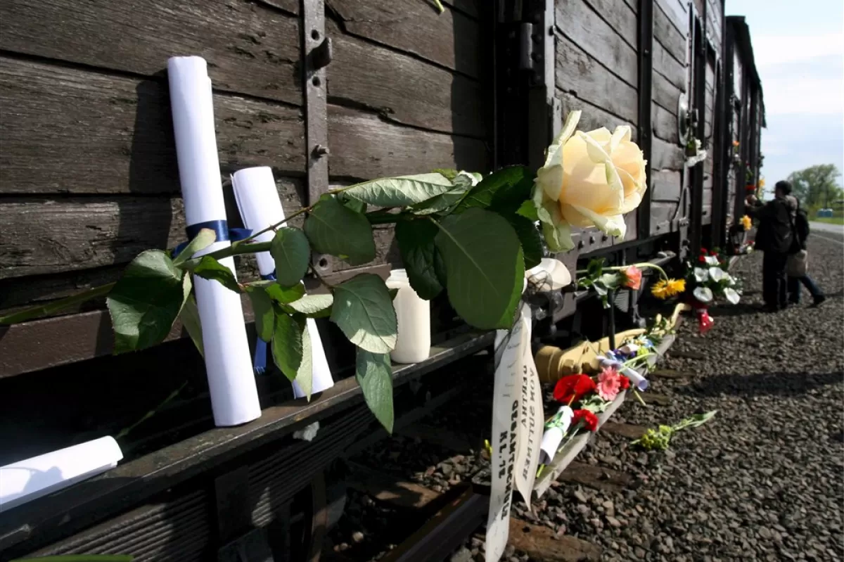 Oamenii au lăsat scrisori și flori în apropierea unui vagon de transport de animale, folosit pentru a transporta prizonierii în lagărul nazist de exterminare Auschwitz - Birkenau, 08 mai 2008.