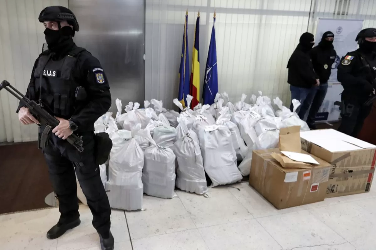 Agenți de poliție păzesc saci cu cocaină confiscată, la sediul Direcției de Investigare a Infracțiunilor de Criminalitate Organizată și Terorism (DIICOT), București, România, 26 martie 2019.