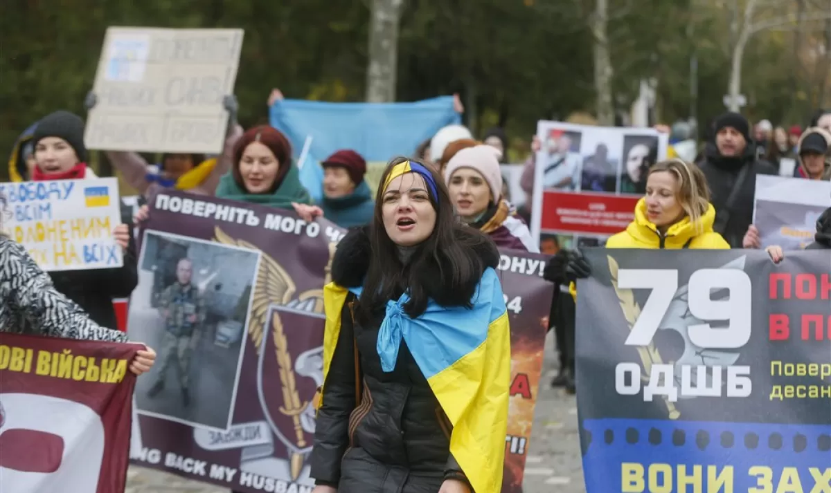 Rudele apărătorilor Azovstal și ale altor prizonieri de război ucraineni țin bannere și fotografii în timp ce participă la un miting la care cer eliberarea lor din captivitatea rusă la Odessa, Ucraina, 26 noiembrie 2022.