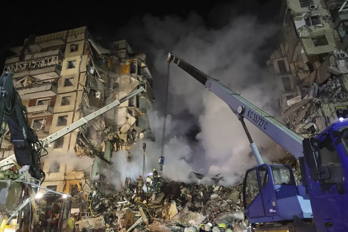 Echipe de salvare lucrează printre dărâmăturile unei clădiri rezidențiale bombardate în Dnipro, sud-estul Ucrainei, 14 ianuarie 2023, pe fondul invaziei Rusiei.