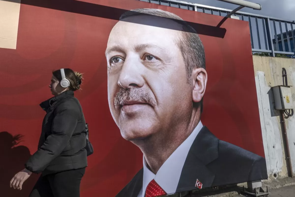 O femeie merge în fața unui afiș cu președintele turc Recep Tayyip Erdogan la Istanbul, Turcia, 18 ianuarie 2023. Președintele Erdogan a anunțat că alegerile prezidențiale ar putea avea loc pe 14 mai 2023, cu o lună mai devreme decât era programat.