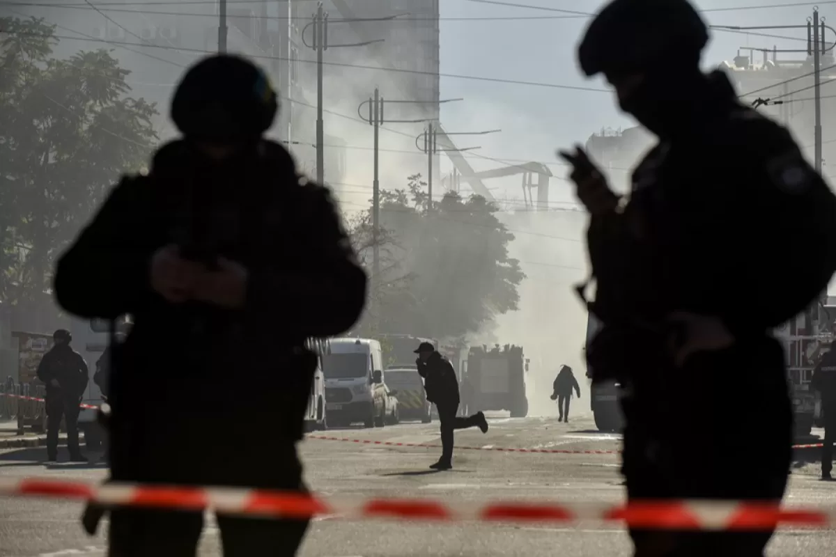 Ofițeri de poliție stau de pază la o clădire rezidențială distrusă într-un atac cu dronă rusă la Kiev, Ucraina, 17 octombrie 2022.