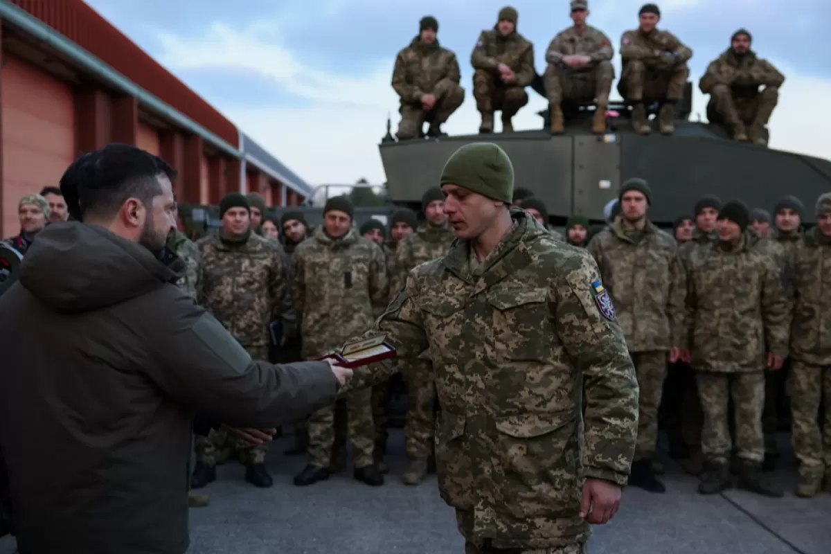 Președintele Ucrainei, Volodimir Zelenski înmânează o medalie în timp ce se întâlnește cu echipaje de tancuri din forțele armate ale Ucrainei care sunt antrenate să folosească tancuri Challenger 2 de către militari britanici în baza Lulworth, Marea Britanie, 08 februarie 2023.