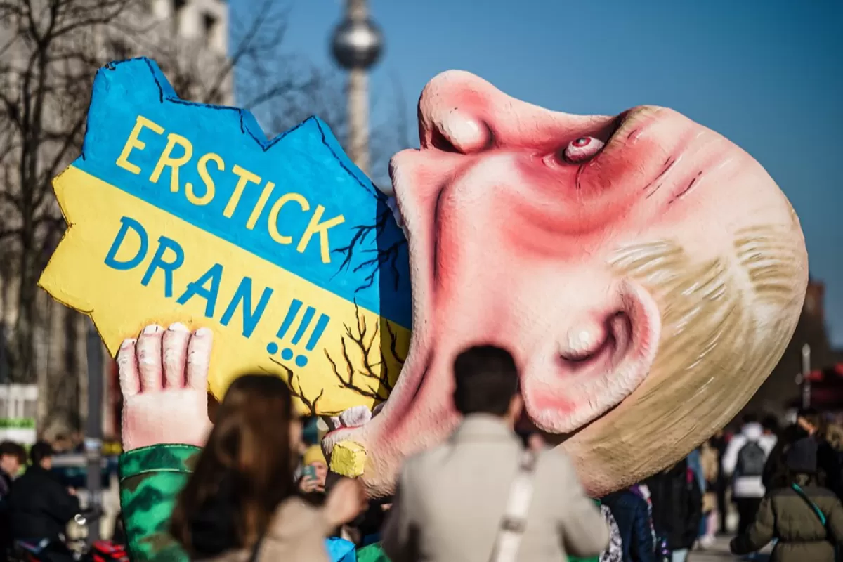 Choke on it !!!' says the slogan of a carnival float showing a depiction of Russian President Putin as he swallows an object in the form and national colors of Ukraine, in the center of a peace protest in Berlin, Germany, 12 March 2022.