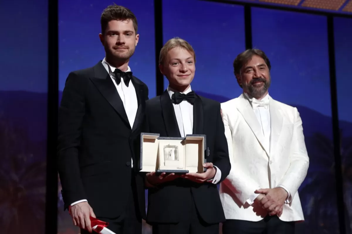Regizorul belgian Lukas Dhont și Eden Dambrine pe scenă cu Javier Bardem după ce au câștigat Marele Premiu al Juriului pentru „Close” în timpul ceremoniei de închidere a celei de-a 75-a ediții a Festivalului de Film de la Cannes, Franța, 28 mai 2022.