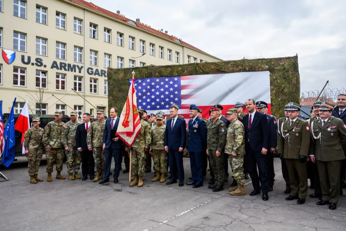 Ministrul polonez al Apărării Mariusz Blaszczak și ambasadorul SUA în Polonia, Mark Brzezinski, pozează pentru o fotografie de grup în timpul ceremoniei de transformare a Grupului de Sprijin Regional al SUA (ASG-P) în Garnizoana Armatei SUA în Polonia (USAG-P.) la Camp Koœciuszko din Poznan , Polonia, 21 martie 2023.