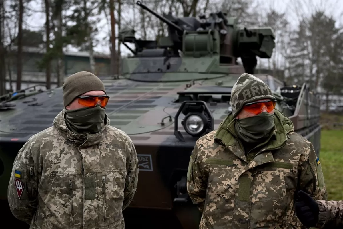 Militari ucraineni stau în fața unui vehicul de luptă al infanteriei germane „Marder” în timpul vizitei ministrului german al apărării la o zonă de antrenament militar din Munster, Germania, 20 februarie 2023.