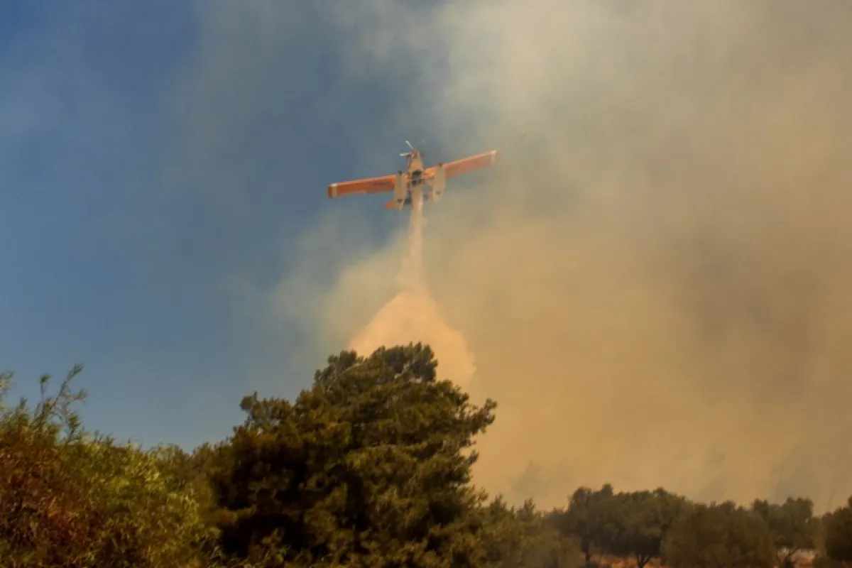 O aeronavă de stingere a incendiilor aruncă apă pentru a stinge un incendiu în satul Vati, pe insula Rodos, Grecia, 25 iulie 2023. Cele mai puternice incendii de până acum sunt pe Rodos și Corfu, a declarat purtătorul de cuvânt al Pompierilor, Yiannis Artopios, pe 25 iulie, în timp ce celelalte incendii s-au reaprins. Reaprinderea dis-de-dimineață în regiunea Vati, sud-estul Rodos, a dus la ordine de evacuare prin sistemul de notificare de urgență 112, care a cerut rezidenților să plece în direcția Lindos. Un total de 266 de pompieri, 16 echipe de teren accidentat, 55 de autospeciale de apă, mai mulți voluntari și agenții de Protecție Civilă activează constant în regiune, a spus Artopios, ajutat de 9 avioane și 4 elicoptere care operează în timpul zilei.