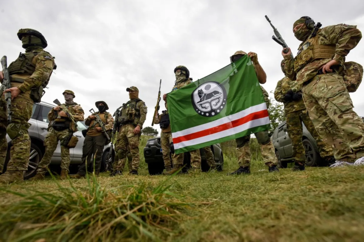 Voluntari din batalionul Djokhar Dudaiev pozează cu un steag al așa-numitei Republici Cecene Ichkeria, în timpul unui exercițiu într-o locație nedezvăluită din zona Kiev, Ucraina, 28 august 2022.