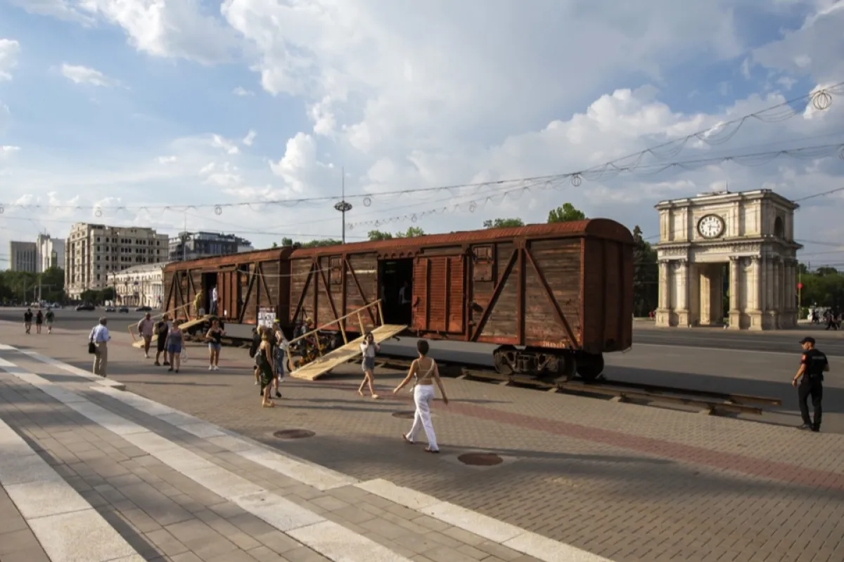 Oamenii vizitează două vagoane vechi de tren de marfă expuse în cadrul expoziției „Basarabeni în Gulag”, dedicată victimelor deportărilor regimului stalinist în Piața Marii Adunări Naționale din Chișinău, Moldova, 06 iulie 2023.