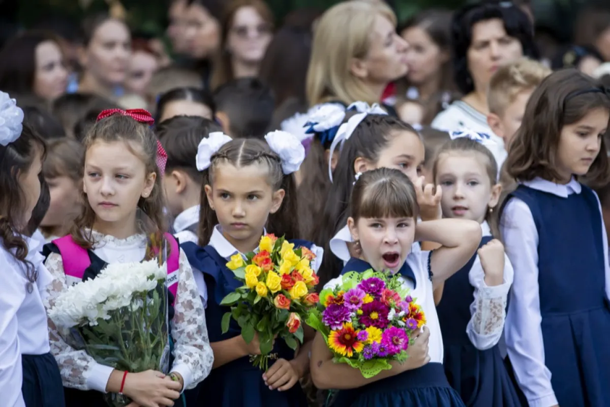 A little girl yawns during the opening ceremony of scholar year at a lyceum named after Moldovan writer Gheorghe Asachi in Chisinau, Moldova, 01 September 2023.