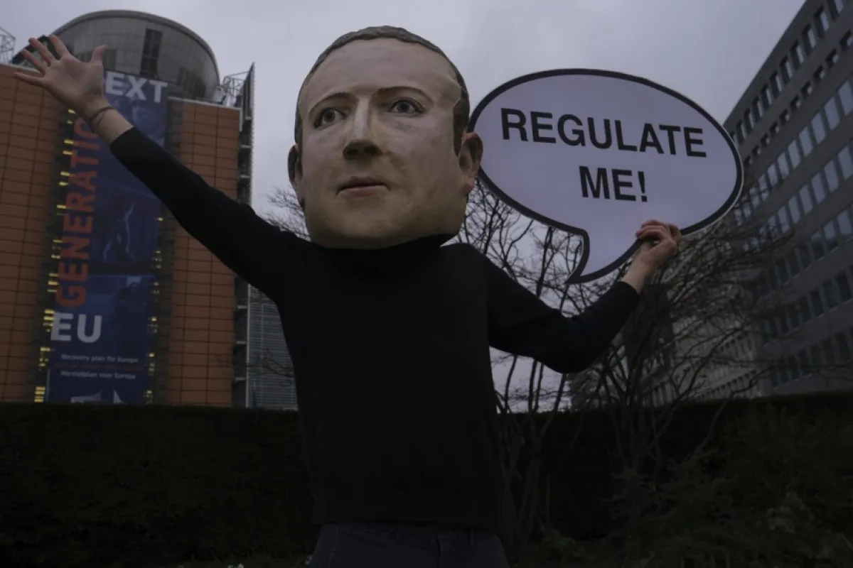 Activist Avaaz deghizat în CEO-ul Facebook, Mark Zuckerberg, spunând „reglementați-mă”, pozează în fața sediului Comisiei Europene din Bruxelles, Belgia, 15 decembrie 2020.