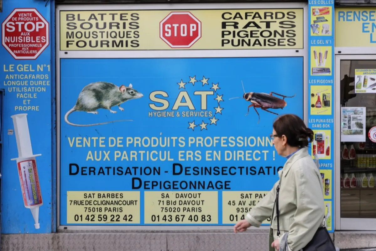 O femeie trece pe lângă un magazin de combatere a dăunătorilor din Paris, Franța, 4 octombrie 2023.