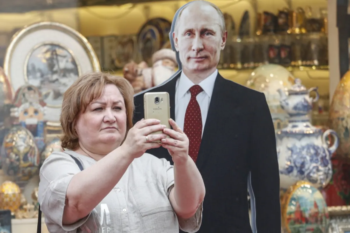 O femeie face fotografii cu o imagine din carton a președintelui rus Vladimir Putin în centrul orașului Moscova, Rusia, 28 iunie 2023.