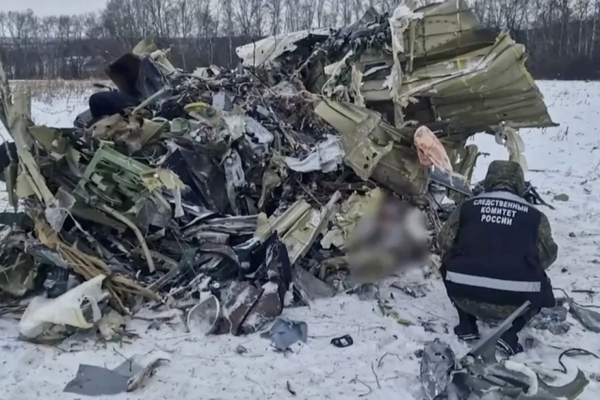 O imagine statică luată dintr-un material video furnizat de Comitetul de Investigații al Rusiei arată un anchetator rus examinând resturi la locul prăbușirii unui avion de transport militar Ilyushin Il-76, lângă satul Yablonovo, regiunea Belgorod, Rusia, 25 ianuarie 2024.