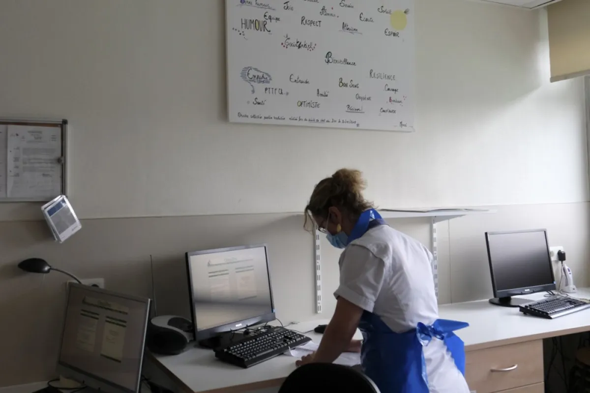 O asistentă a spitalului CHR Sambre et Meuse introduce date într-un computer în timp ce tratează un pacient infectat cu coronavirusul SARS-CoV-2 care provoacă boala pandemică COVID-19, în Namur, Belgia, 28 aprilie 2020.