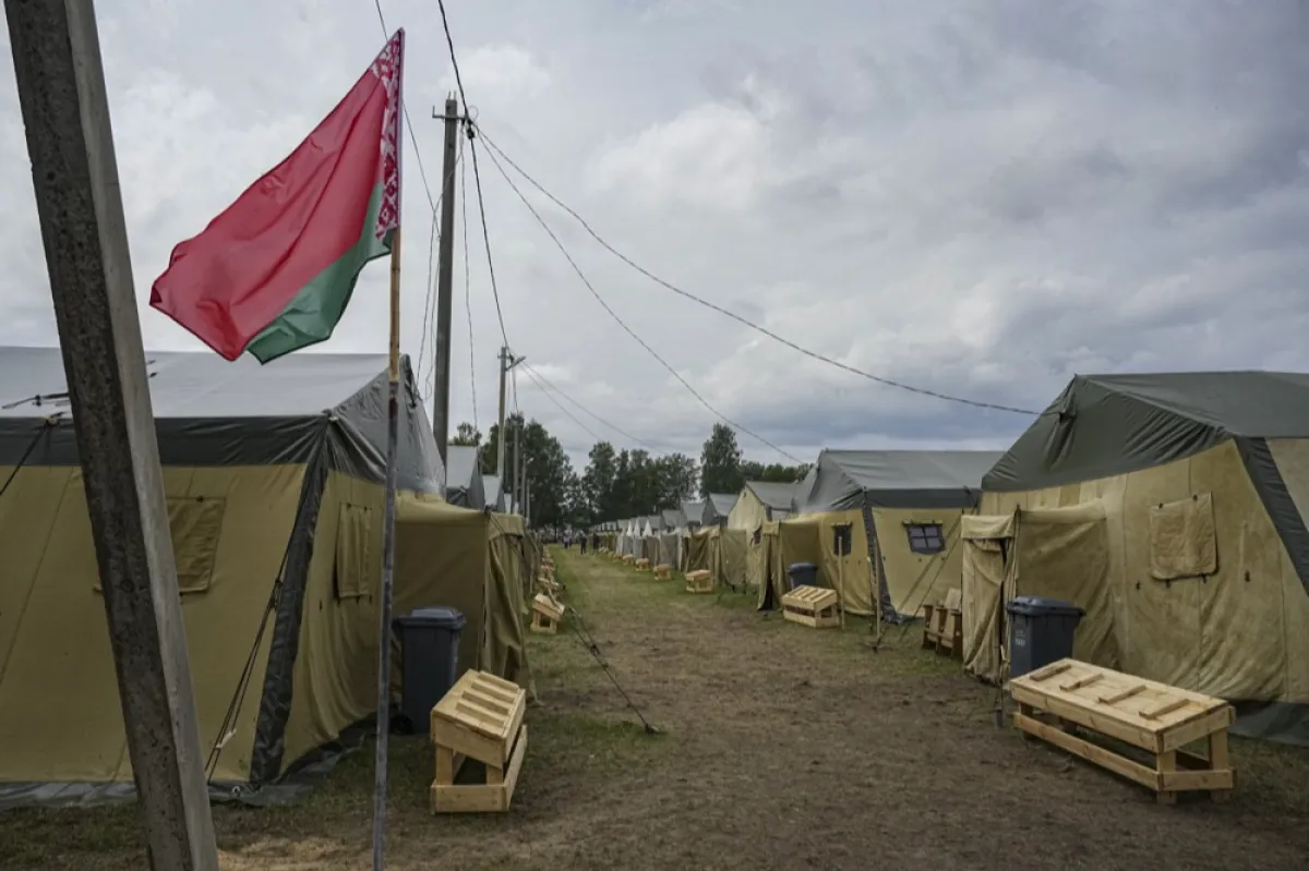 Steagul național al Belarusului flutură în apropierea corturilor dintr-o tabără a armatei belaruse lângă satul Cel, la aproximativ 90 de km sud-est de Minsk, Belarus, 7 iulie 2023.