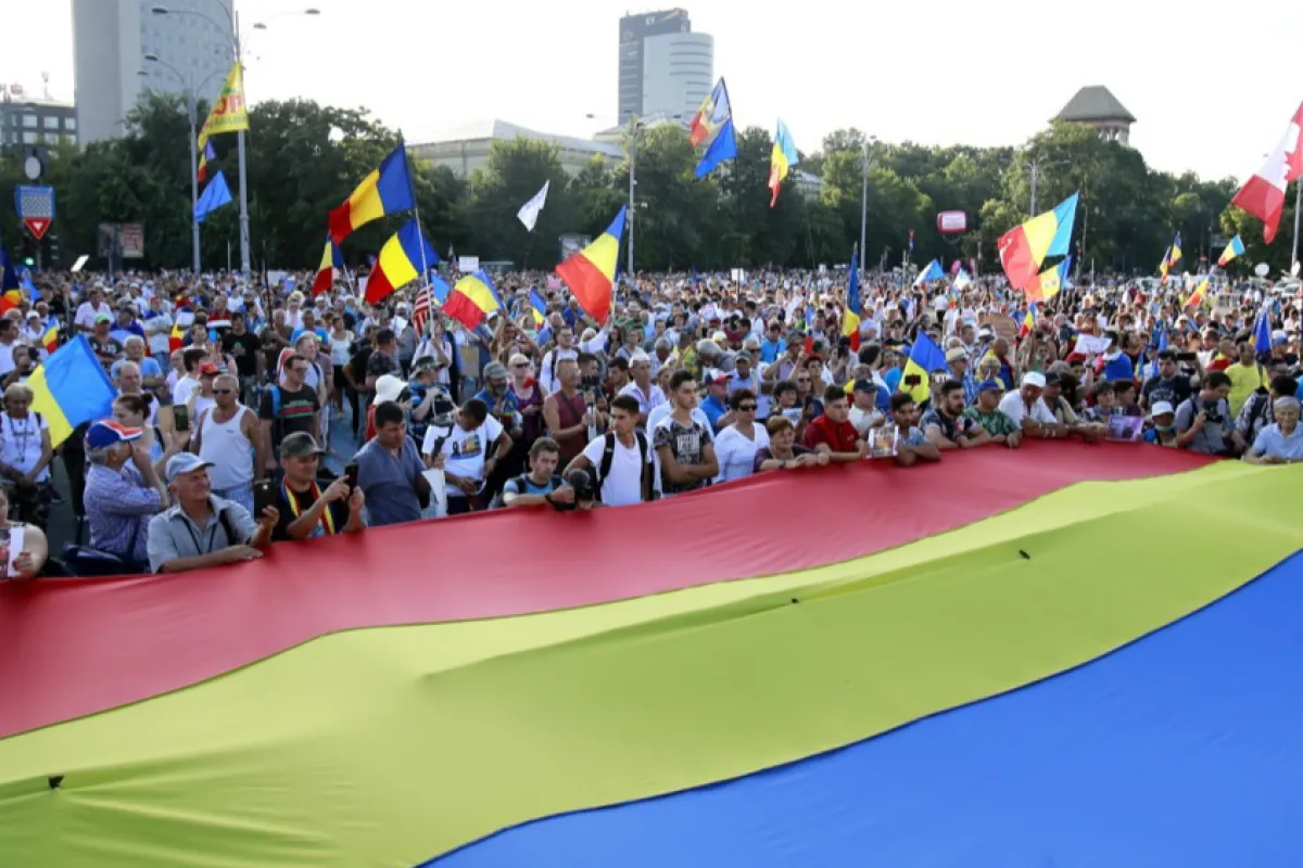 Protestatari români flutură drapelul național în timpul unui protest al diasporei împotriva guvernului de stânga, desfășurat în fața sediului guvernului, la București, România, 10 august 2019.